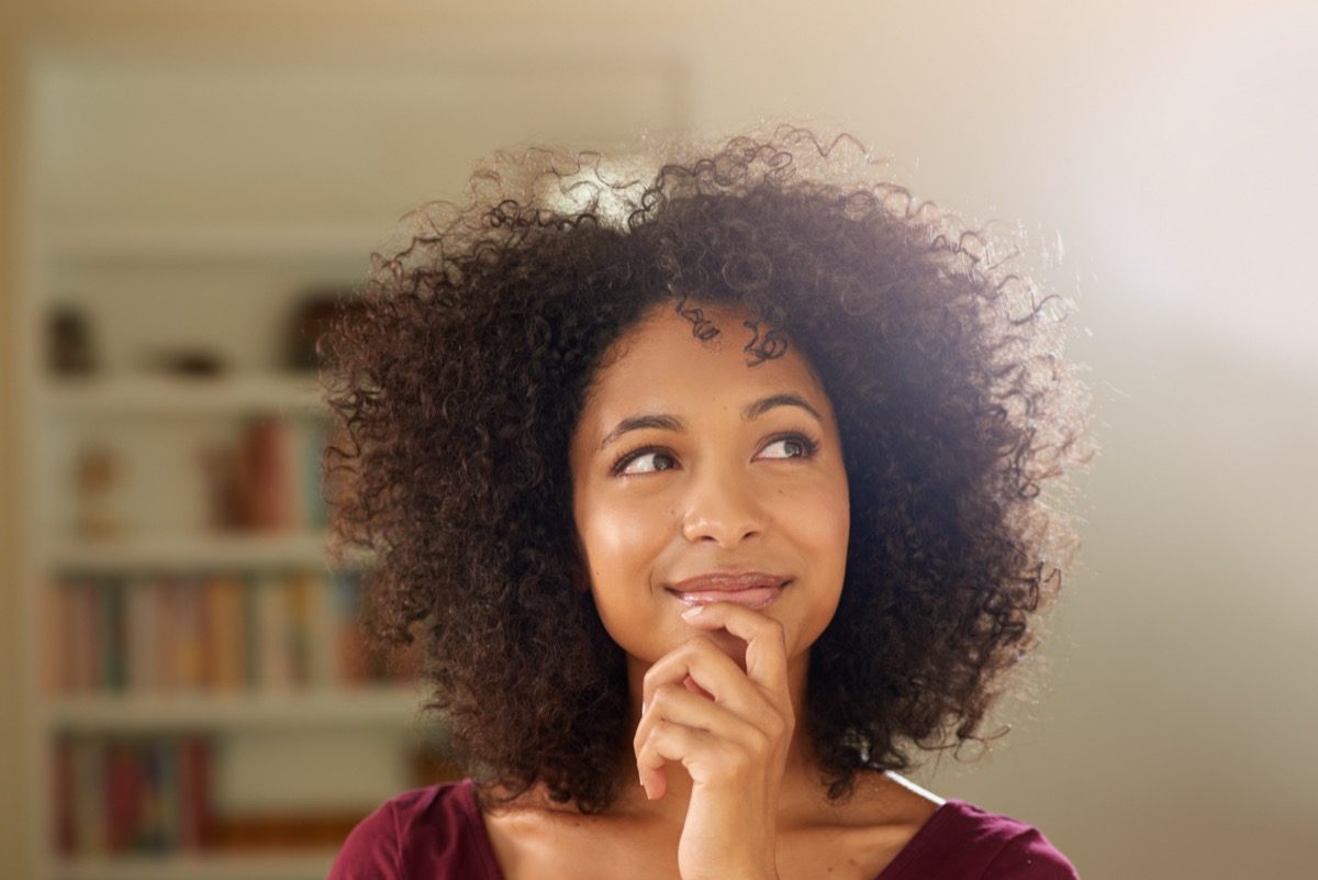 A thoughtful-looking young woman at home