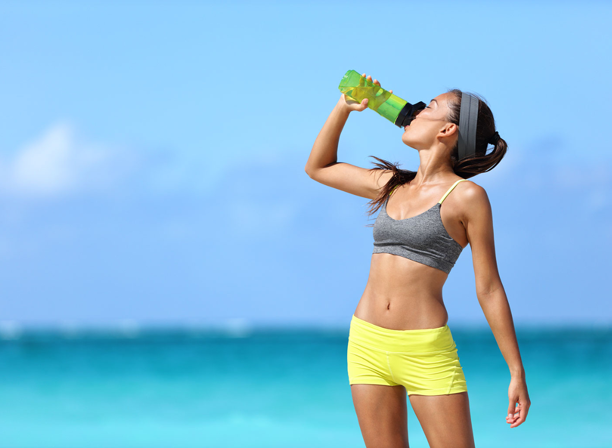 woman drinking water on beach