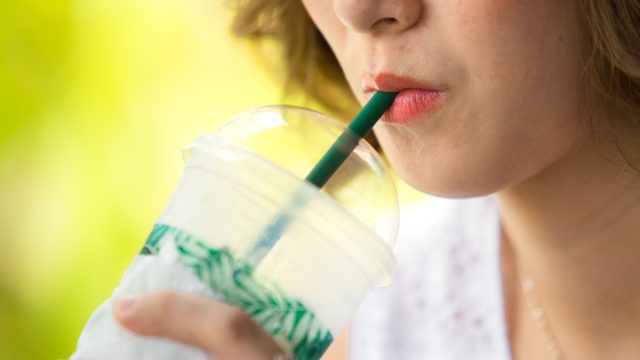 woman drinking iced coffee with a straw
