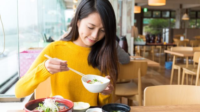 young woman eating japanese food