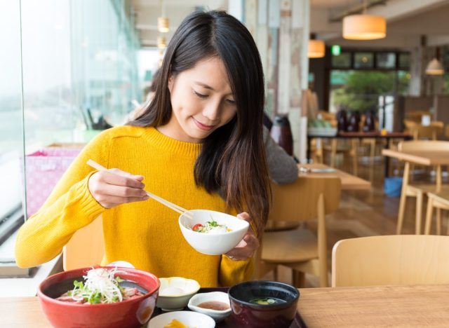 young woman eating japanese food