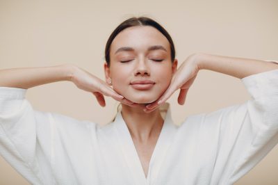 Young woman doing face building yoga facial gymnastics self massage and rejuvenating exercises