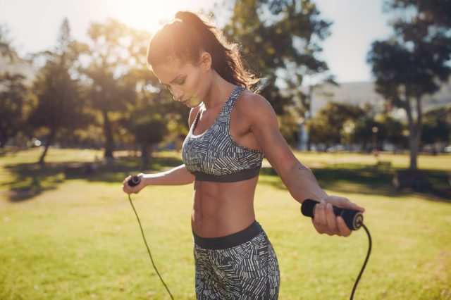 woman doing jump rope exercise outdoors