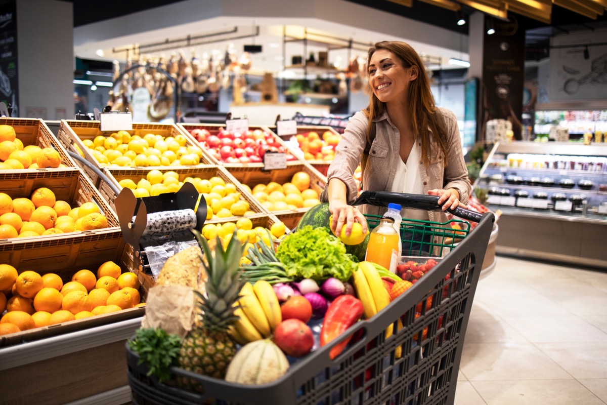 young woman buying lots of fruit