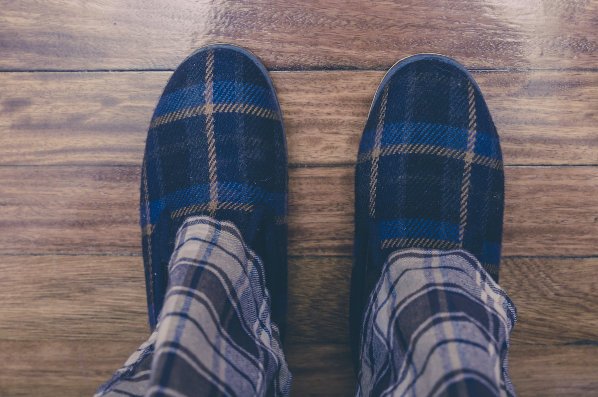 Man feet at home in pajamas and winter slippers