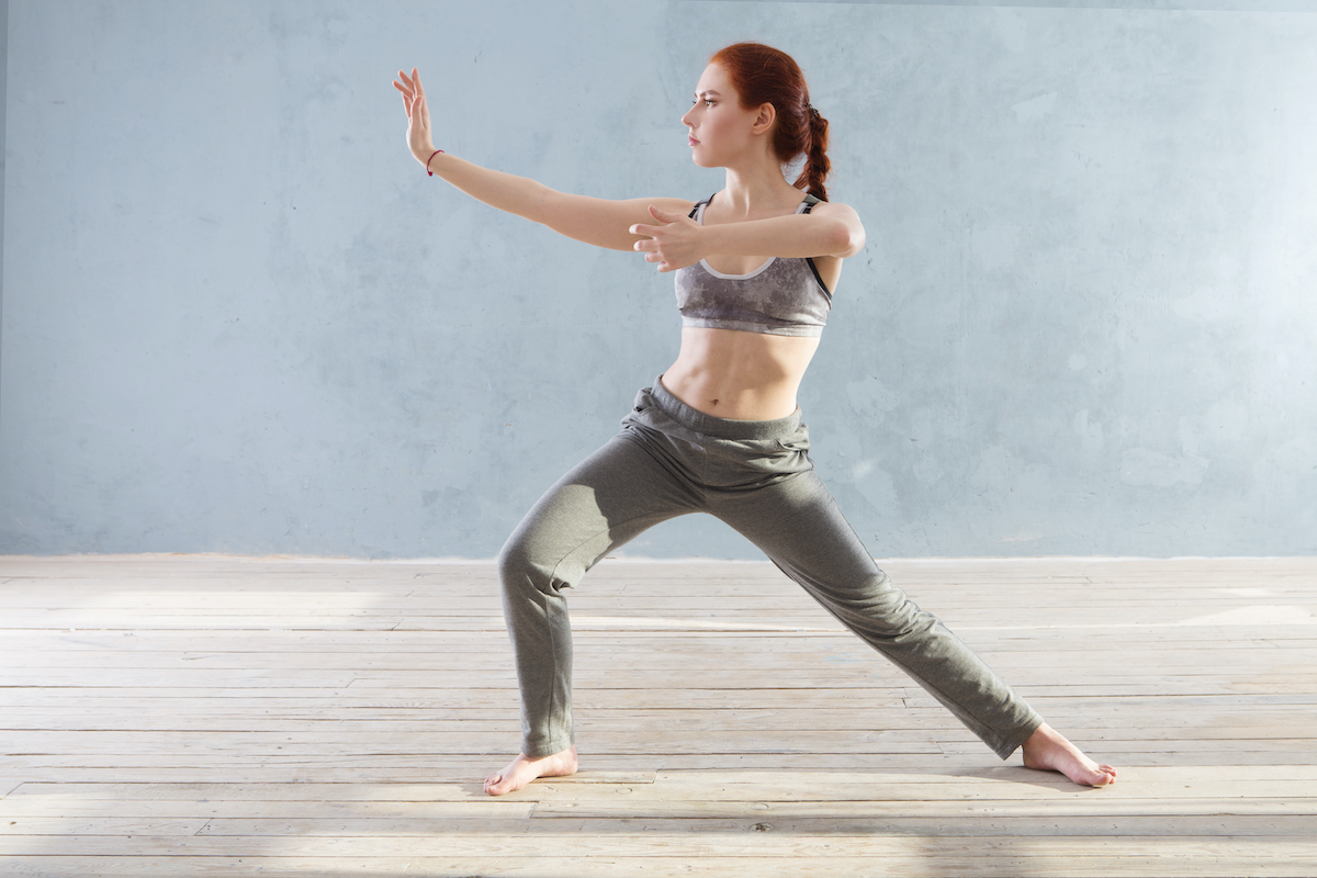 Young Woman praticing tai chi chuan in the gym. Chinese management skill Qi's energy.