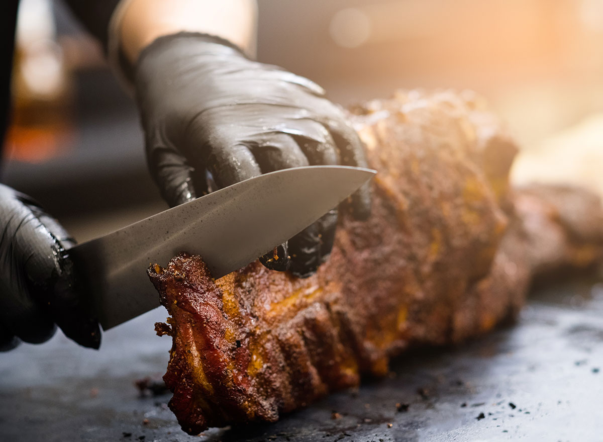 cook cutting bbq meat