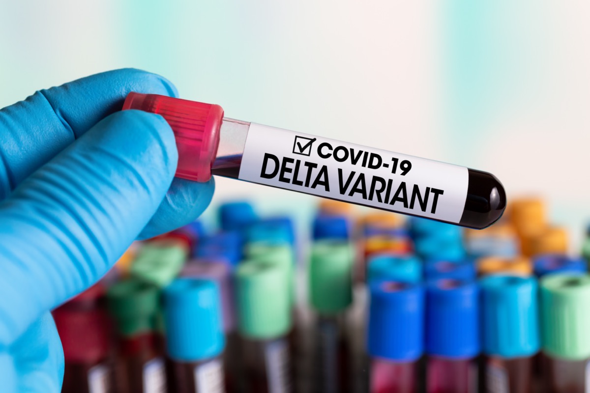 Technician holding tube of blood test identified with the label Covid-19 DELTA Variant.