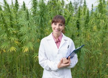 Female doctor with clipboard posing in a hemp field