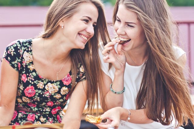 two female friends eating outdoors