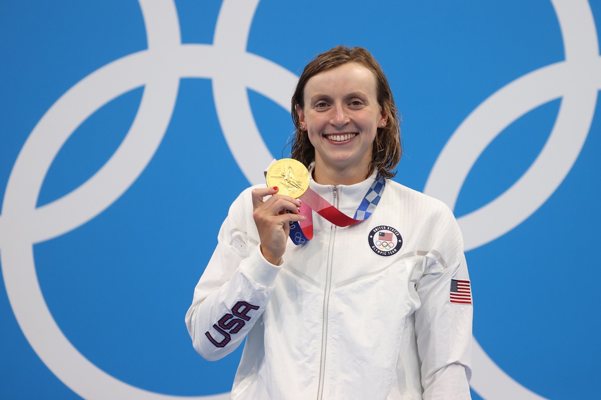 olympian katie ledecky holding up her medal at the 2021 tokyo olympics