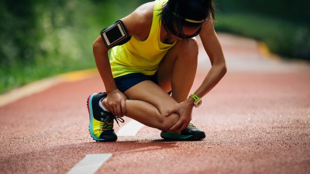 Female runner suffering with pain on sports running knee injury