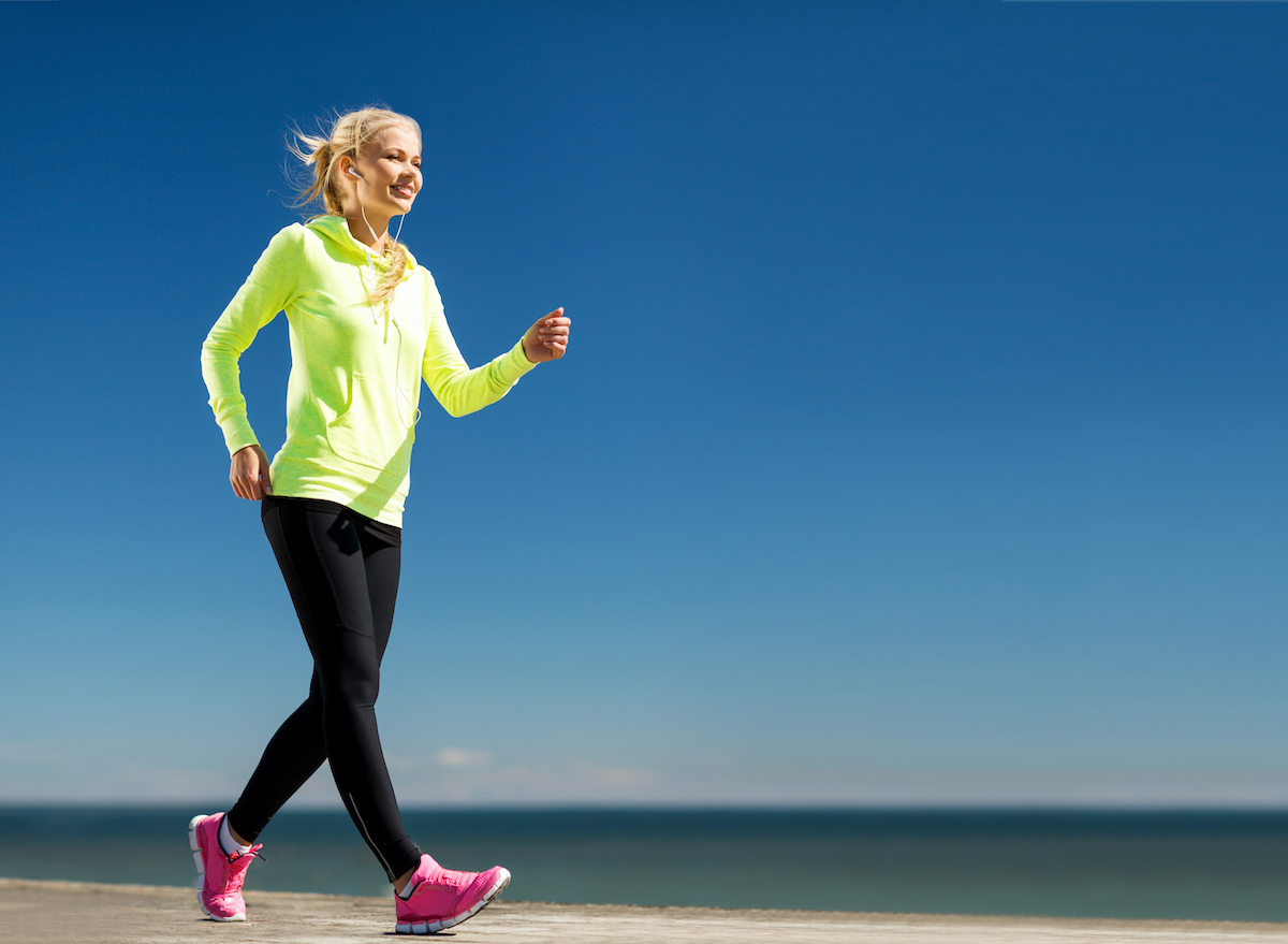 blonde woman walking with good posture and form on beach