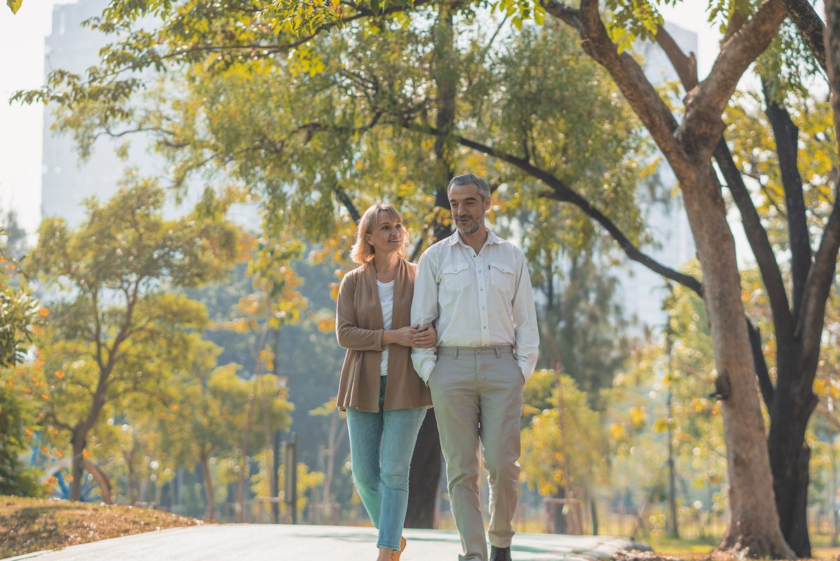 older-couple-walking-outside-in-park