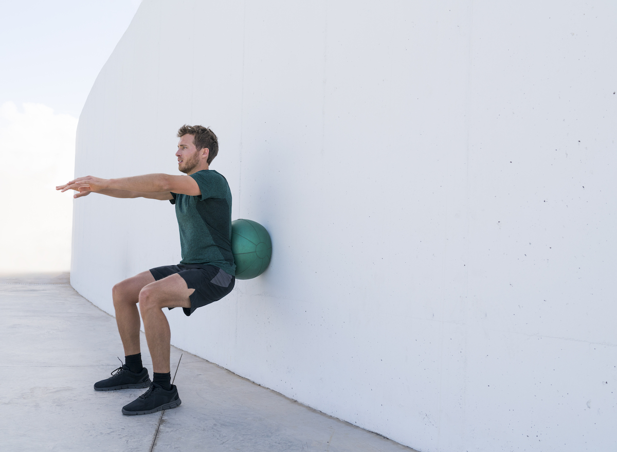 man-practicing-stability-ball-squats