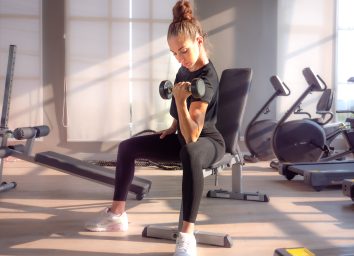 woman-lifting-dumbbells-at-gym