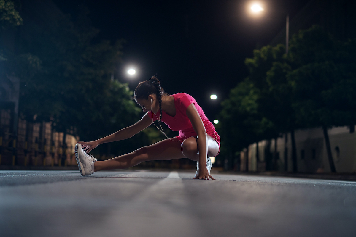 Young girl doing fitness outdoors at night.