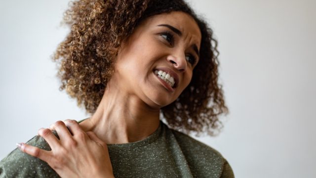 Woman experiencing neck pain.