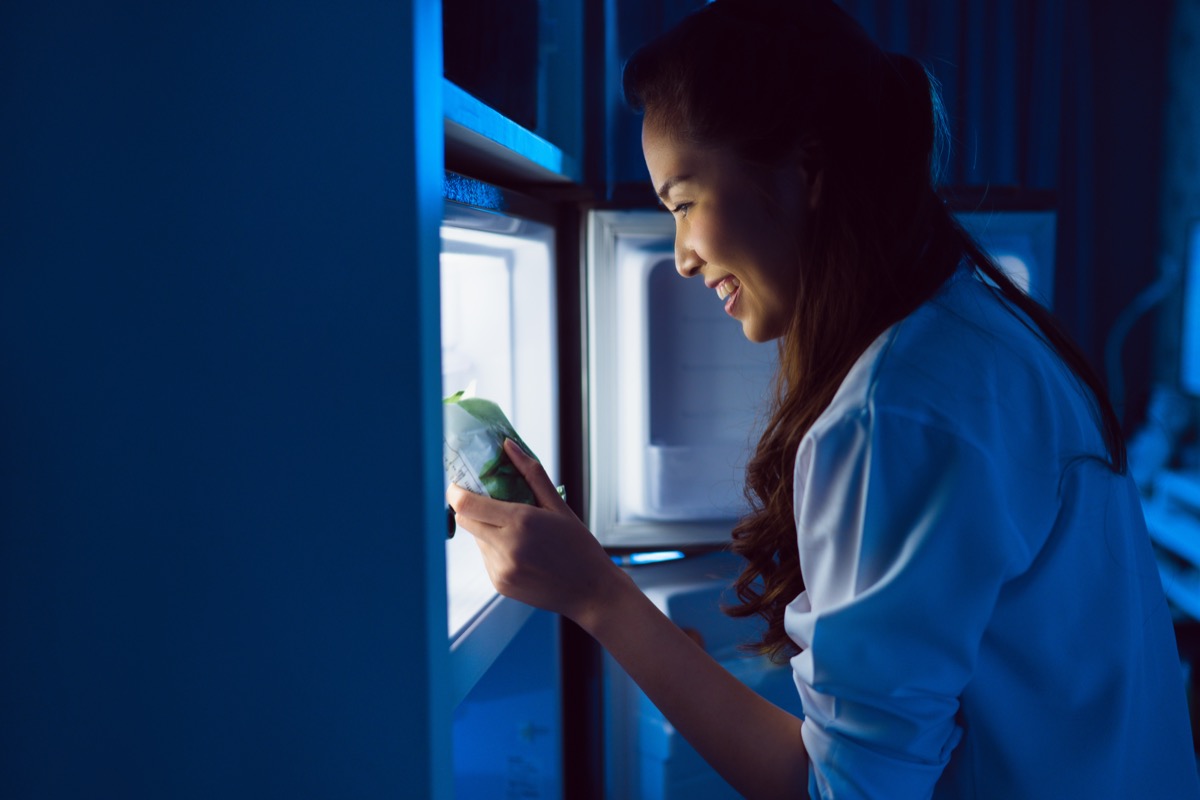 women grabbing snack and eating at night