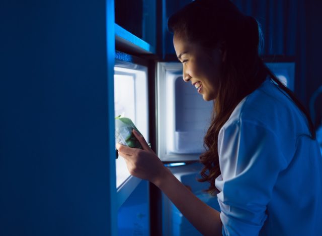 women grabbing snack and eating at night
