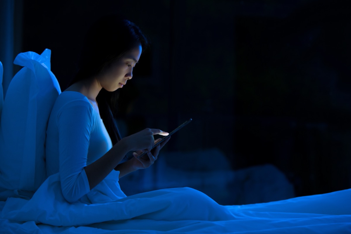 young woman using tablet in bed