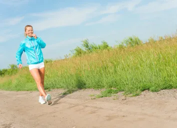 young woman running along a rural road, exercise outdoors