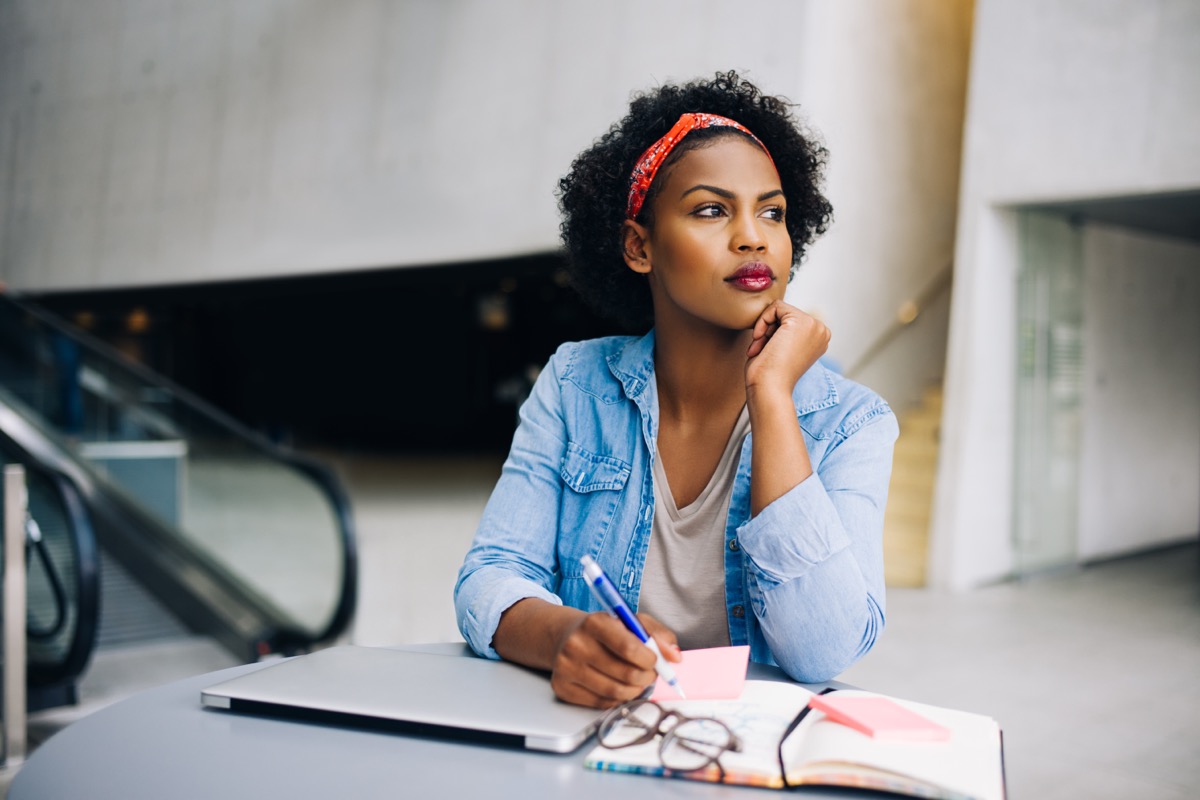 young woman daydreaming at work in a modern office building