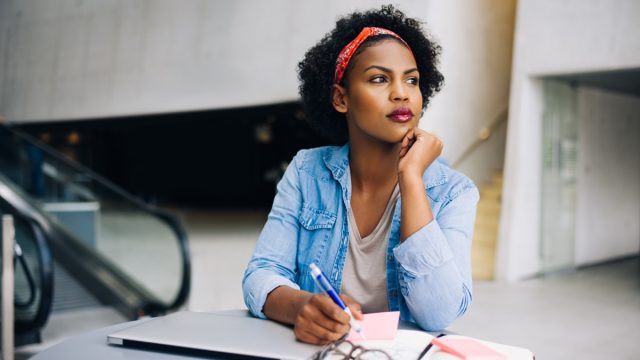young woman daydreaming at work in a modern office building