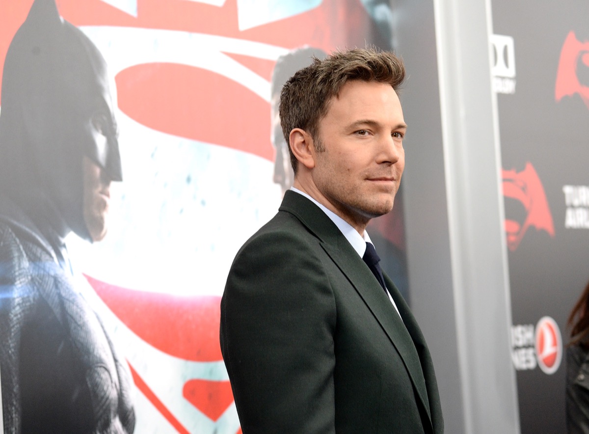 ben affleck in a black suit smiling on the red carpet