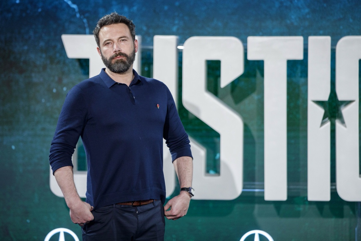 ben affleck posing in front of justice league banner