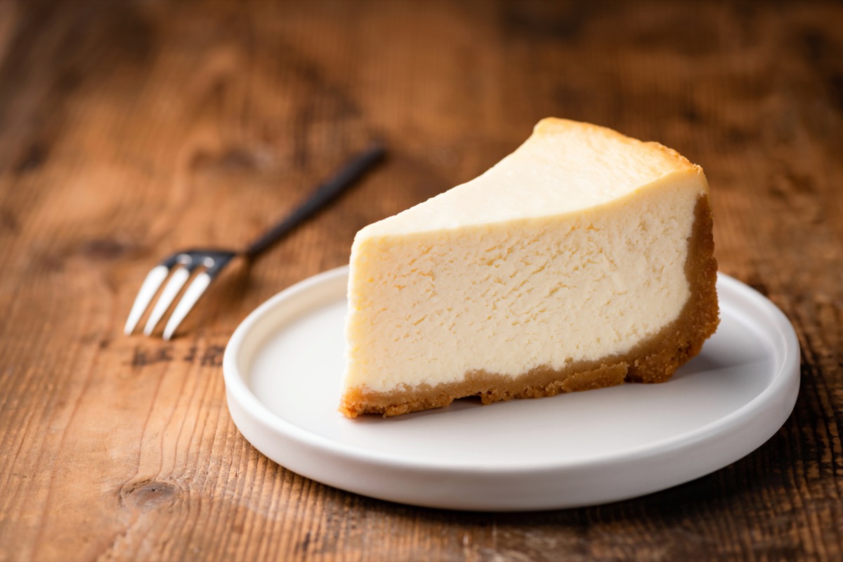 slice of cheesecake on white plate on wooden table