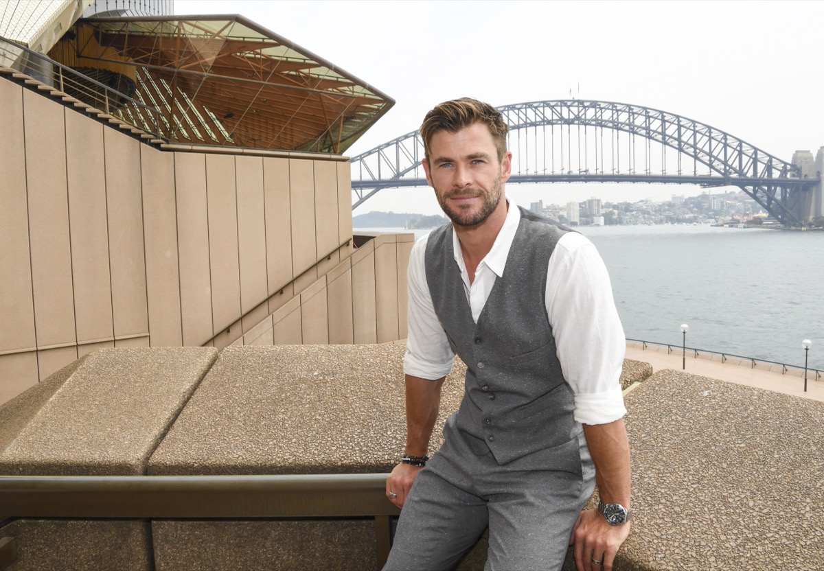 chris hemsworth sitting outside in gray suit