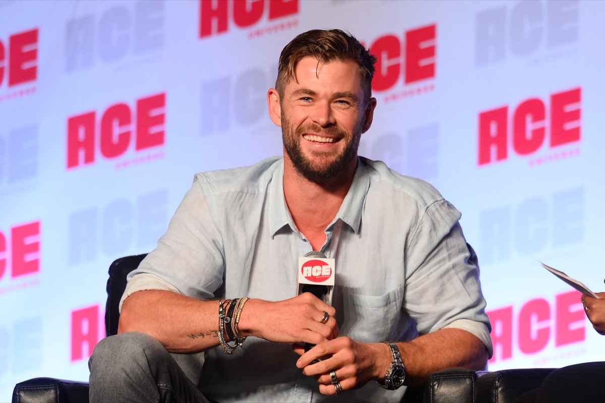 chris hemsworth sitting down and smiling
