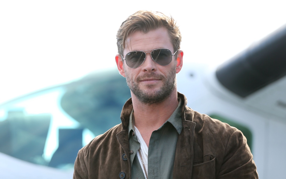 chris hemsworth in sunglasses standing outdoors