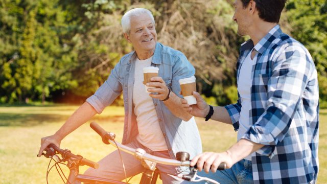 two men on bikes drinking coffee