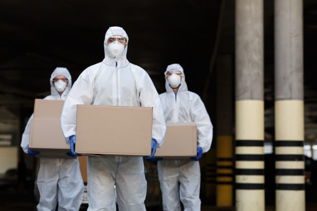 People in protective suits and masks delivering the coronavirus vaccine.