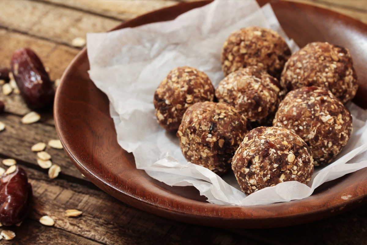 energy balls on parchment paper inside wooden bowl