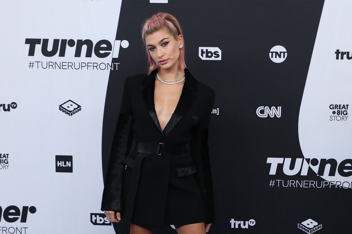 hailey bieber with pink hair in a black jacket