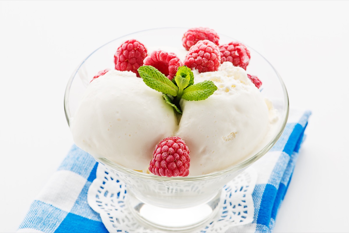 vanilla ice cream in glass dish with raspberries and mint leaves