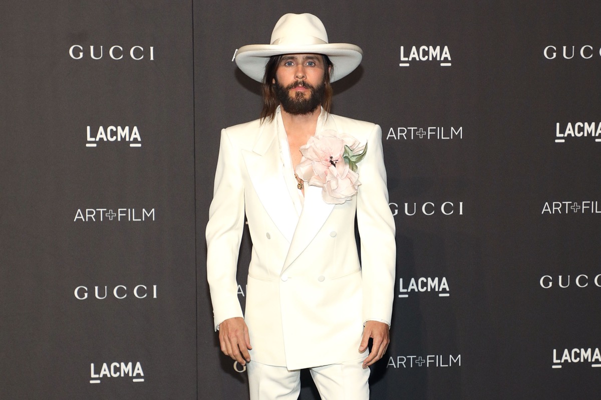 jared leto in white suit and cowboy hat on red carpet