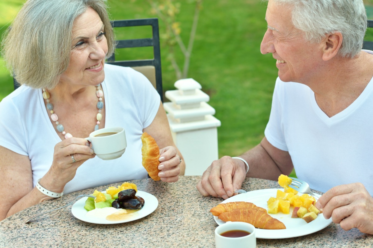 older couple eating croissants for breakfast