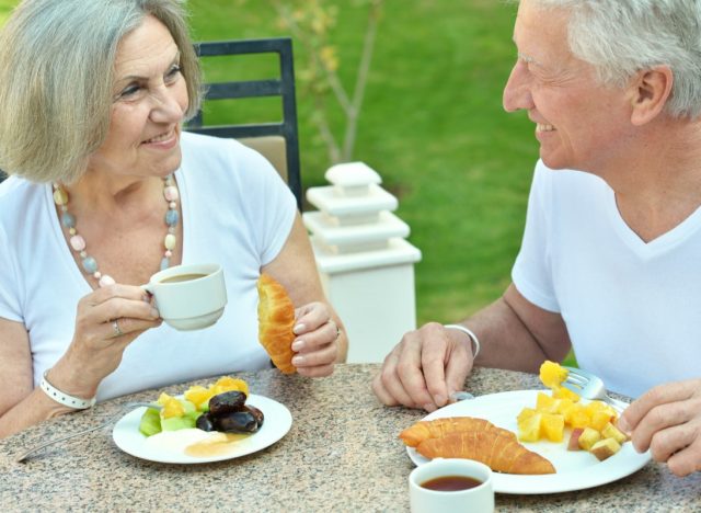 older couple eating croissants for breakfast