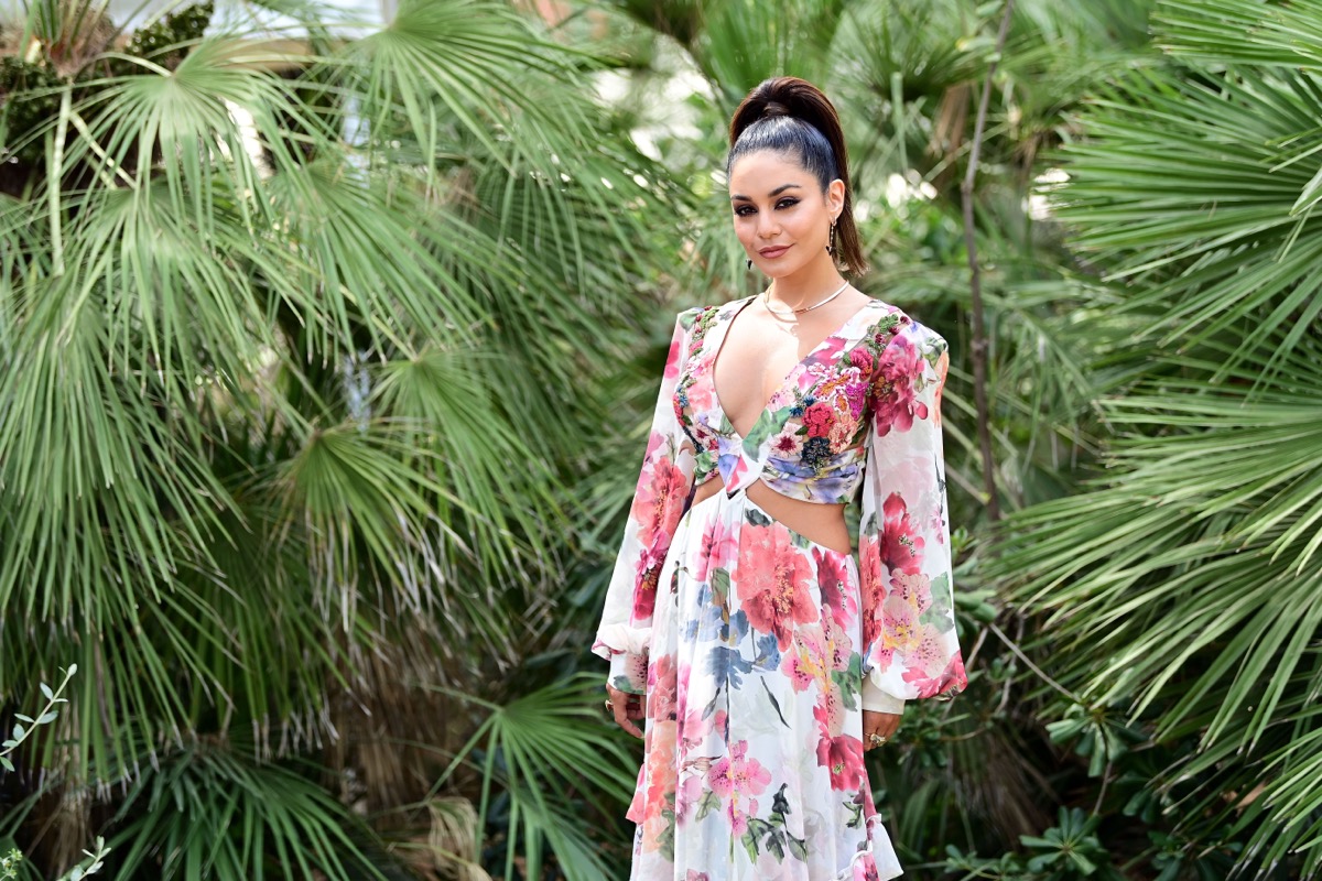 vanessa hudgens in long floral dress in front of greenery