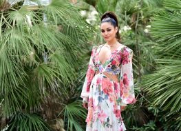 vanessa hudgens in long floral dress in front of greenery