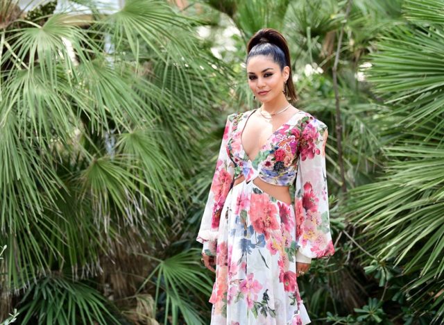 vanessa hudgens in long floral dress in front of greenery