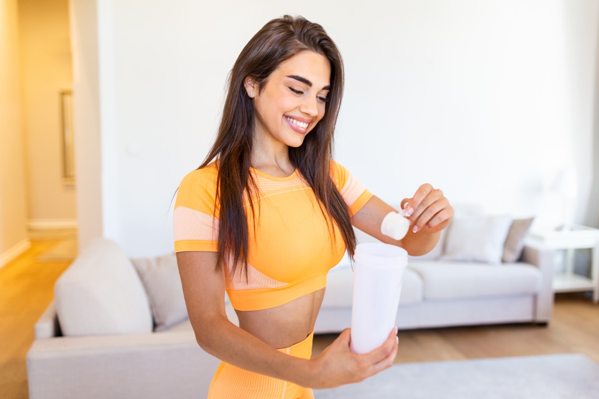 young woman making protein shake