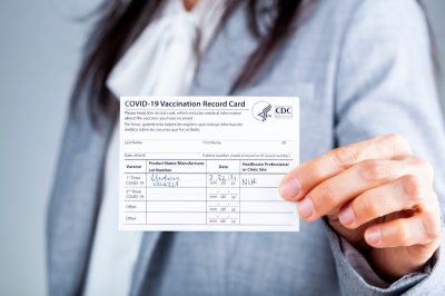 Woman is presenting COVID vaccination card.