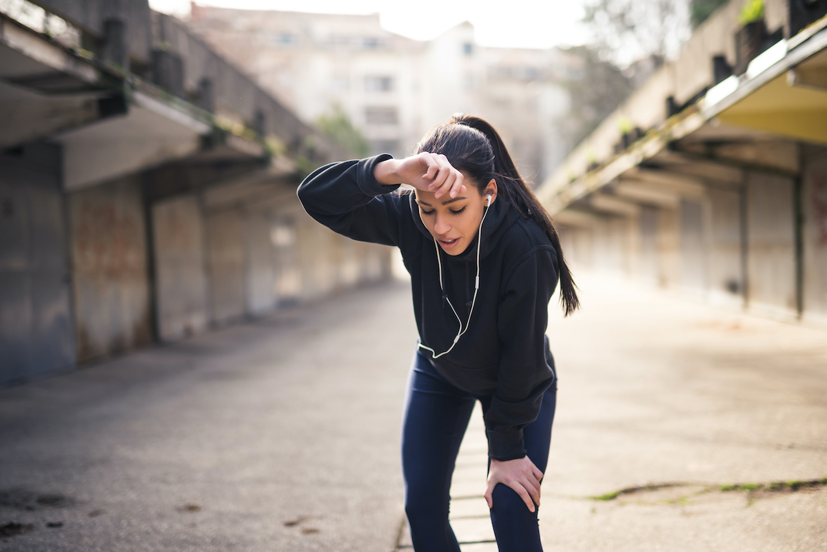 Woman wiping sweat from forehead after a heavy training.