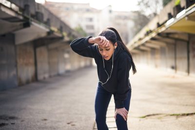 Woman wiping sweat from forehead after a heavy training.