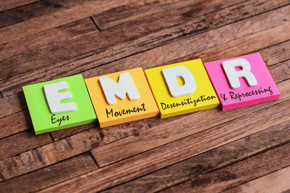 Colorful square papers with wooden white letters for the English acronym word, EMDR